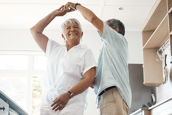 Happy senior couple dancing in the kitchen