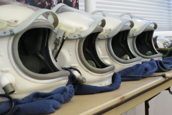 Space suit helmets sitting in a row