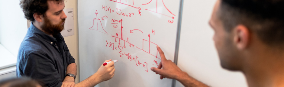 Group of engineering students working on a whiteboard