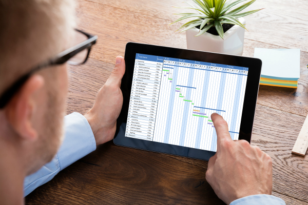 Project Management Professional (PMP) using a tablet to work on a project plan