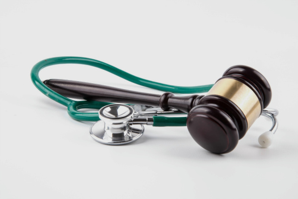 Stethoscope and gavel sitting on a white table