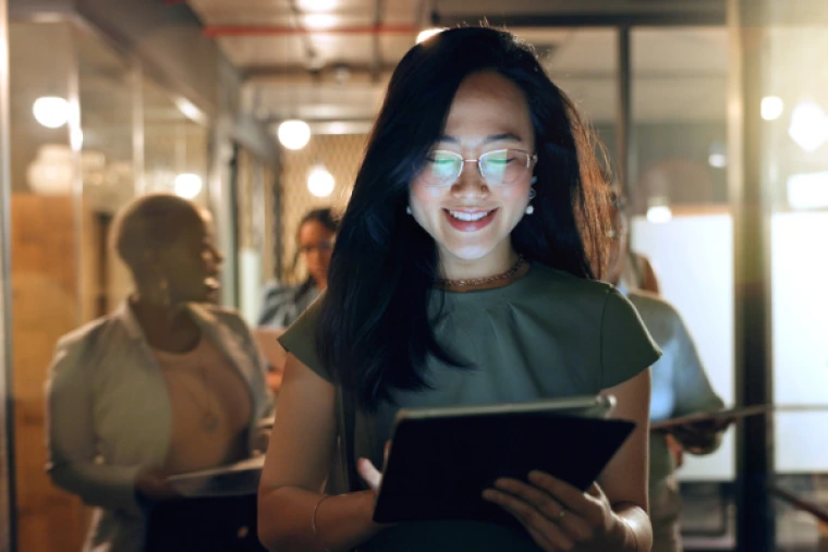 Smiling project manager reviewing project plan on a tablet