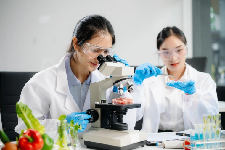 Two women looking at a microscope