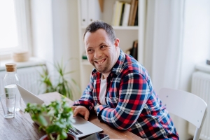Man with Down Syndrome working on a computer in an office.