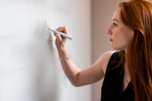 Female IT project manager writing on a whiteboard