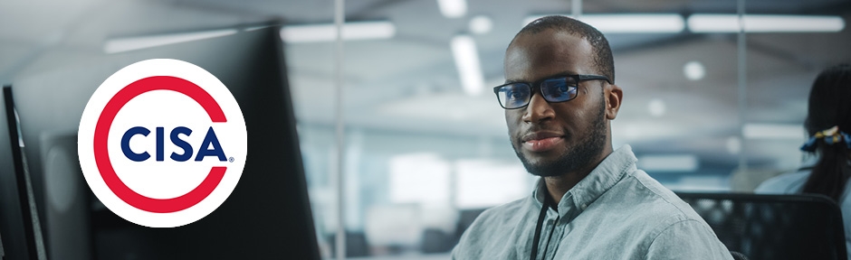 Smiling Certified Information Systems Manager working on his computer with ISACA CISA logo overlaid on image