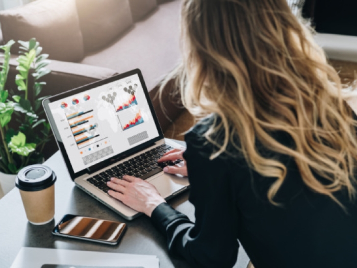Business analyst looking at data analysis on laptop screen