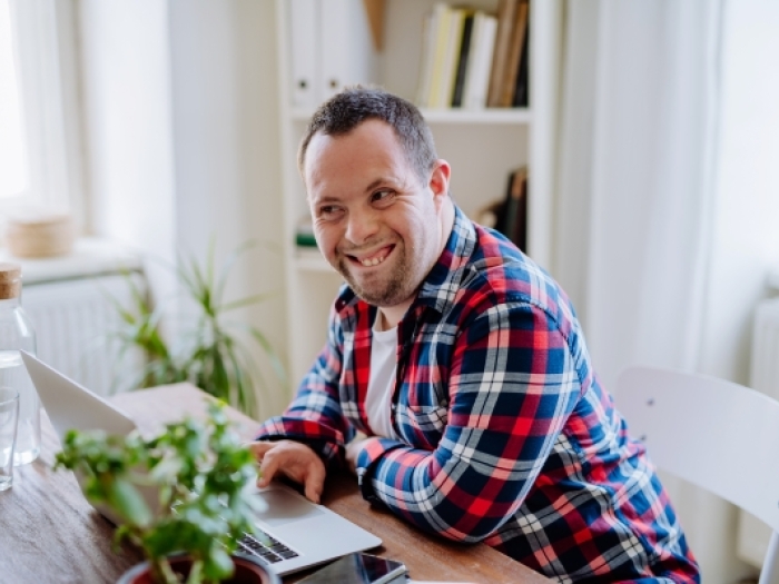 Man with Down Syndrome working on a computer in an office.