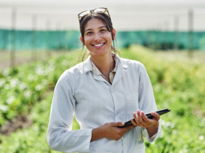 Female worker in a greenhouse monitoring hydroponics system