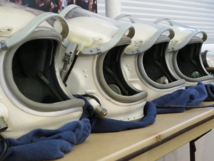 Space suit helmets sitting in a row