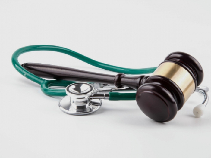 Stethoscope and gavel sitting on a white table
